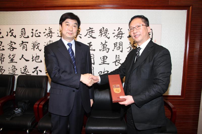 Mr Yuen (right) receives a souvenir from the Vice Minister of Justice, Mr Hao Chiyong, yesterday.