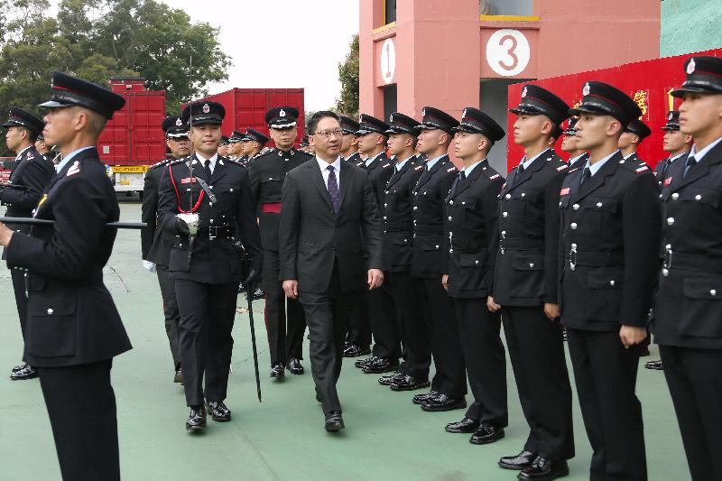 The Secretary for Justice, Mr Rimsky Yuen, SC, reviews a passing-out parade at the Fire and Ambulance Services Academy today (April 1).