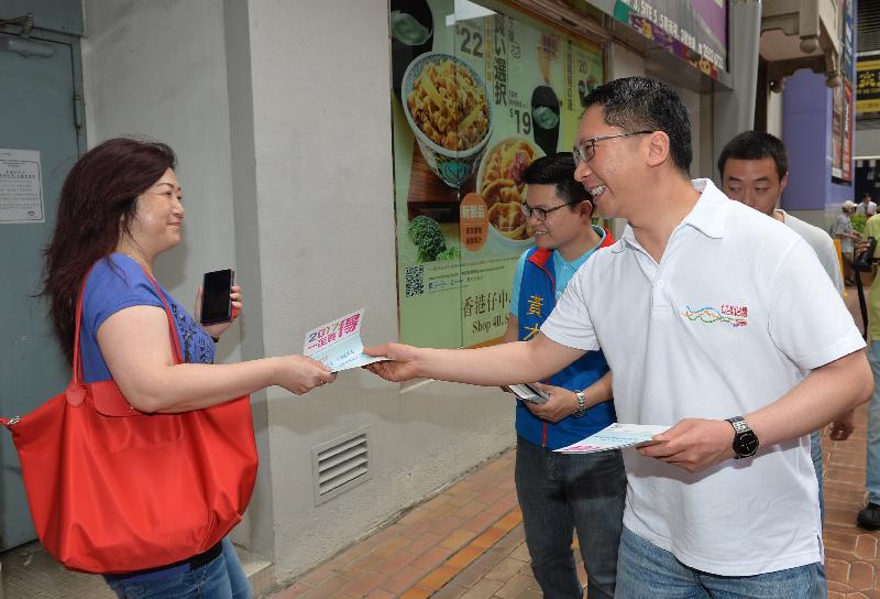 The Secretary for Justice, Mr Rimsky Yuen, SC (right), distributes leaflets to a member of the public.