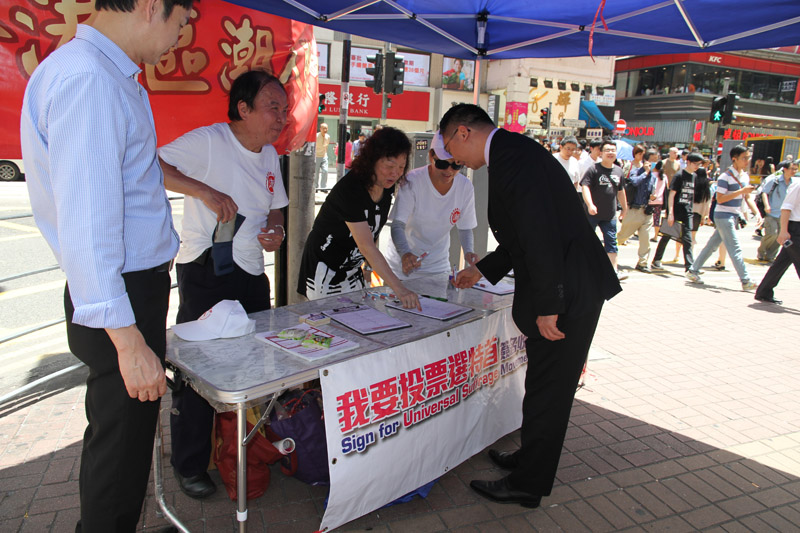 The Secretary for Justice, Mr Rimsky Yuen, SC (first right), this afternoon (May 15) joins a signature campaign in Wan Chai to support for the Government's proposals for selecting the Chief Executive by universal suffrage.