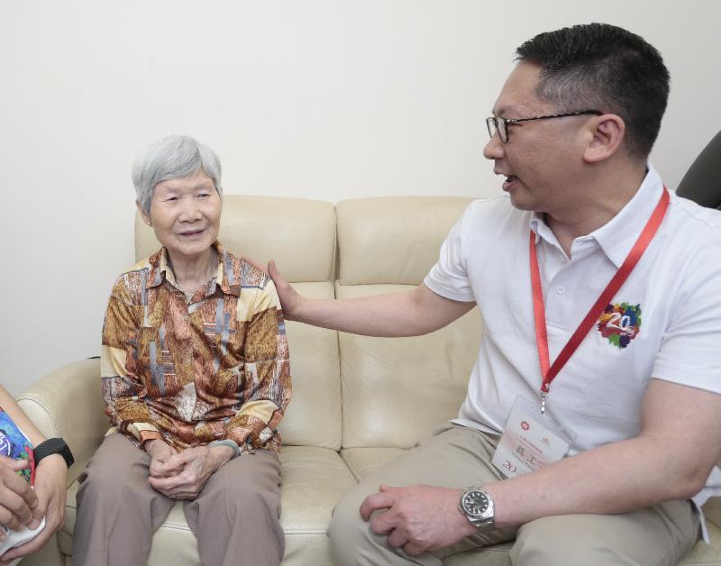 The Secretary for Justice, Mr Rimsky Yuen, SC (right), today (June 27) chats with an elderly woman when he conducts home visits in Wan Chai District to learn more about families' living conditions and needs.
