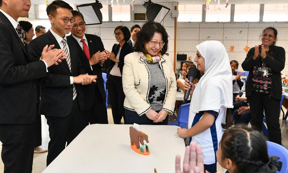 The Secretary for Justice, Ms Teresa Cheng, SC, visits Yuen Long Long Ping Estate Tung Koon Primary School today (November 23). Photo shows Ms Cheng (centre) being briefed by the students on the "Project HIMALAYA" organised by the Police.