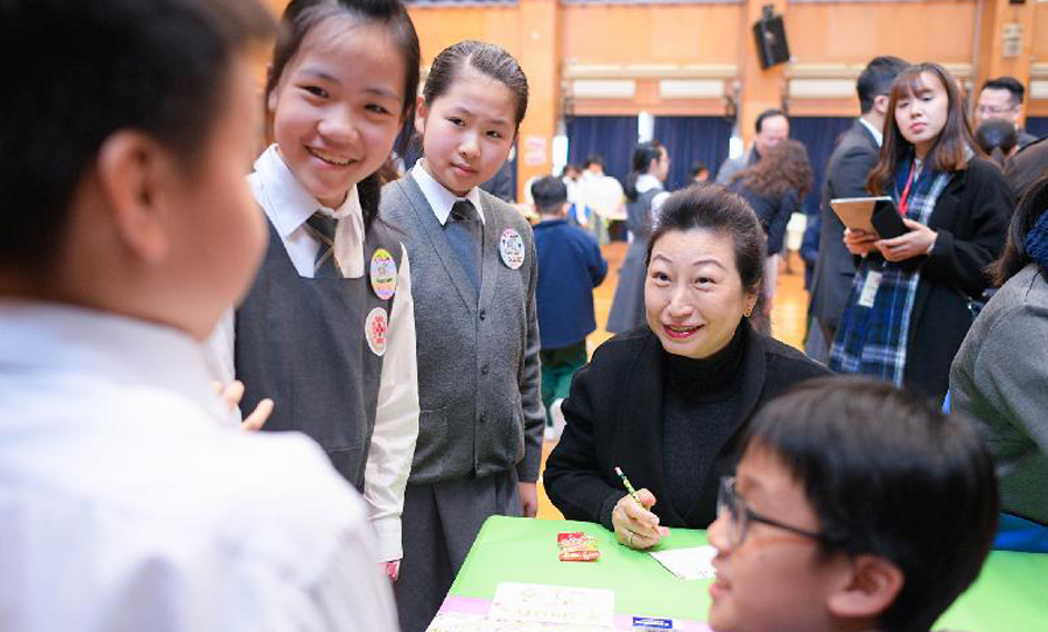 The Secretary for Justice, Ms Teresa Cheng, SC, visits SKH Tak Tin Lee Shiu Keung Primary School in Lam Tin today (December 13). Photo shows Ms Cheng (third left) chatting with students participating in creative English teaching project "SimCity".
