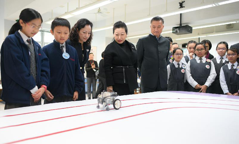 The Secretary for Justice, Ms Teresa Cheng, SC, visits SKH Tak Tin Lee Shiu Keung Primary School in Lam Tin today (December 13). Photo shows Ms Cheng (fourth left) viewing students’ demonstrations on using coding programmes to control robots.