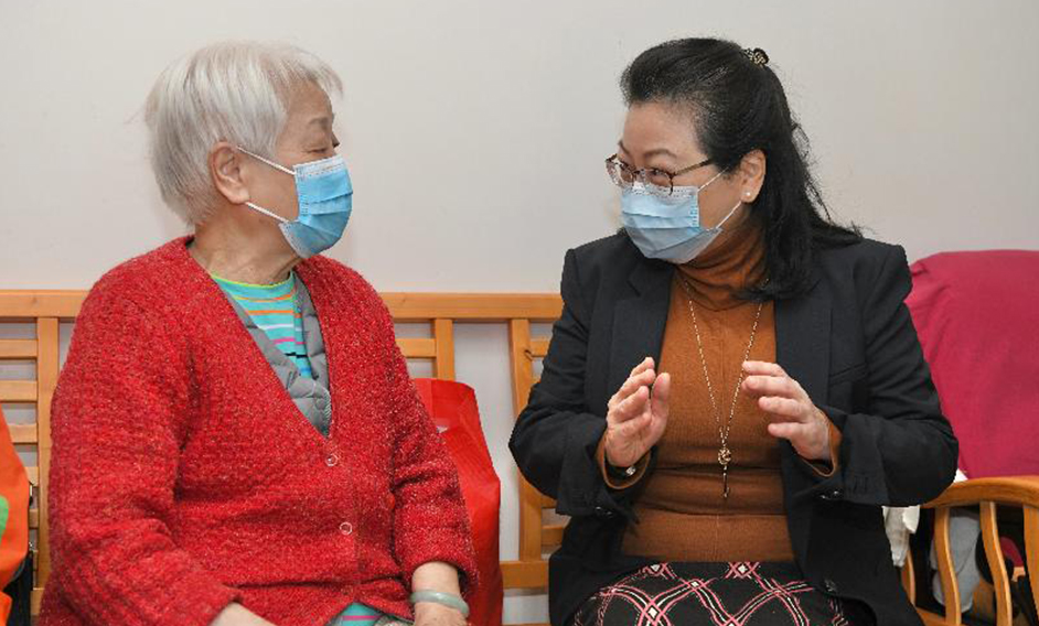 The Secretary for Justice, Ms Teresa Cheng, SC, visited elderly families in Long Shin Estate at Yuen Long today (February 18) to distribute surgical masks, food, leaflets with health information and other goods to them. Picture shows Ms Cheng (right) reminding an elderly resident of the importance of maintaining personal hygiene to prevent the spread of disease.