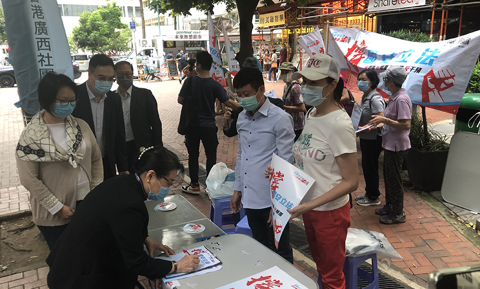 The Secretary for Justice, Ms Teresa Cheng, SC (first left), showed up at a street signature campaign and signed to show her support for national security law.