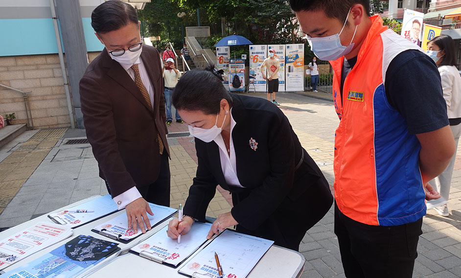 The Secretary for Justice, Ms Teresa Cheng, SC, today (March 17) signs at a street counter in support of the Decision on improving the electoral system of the Hong Kong Special Administrative Region by the National People's Congress and the implementation of the principle of 